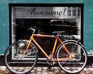 Awesome orange vintage bike in front of window leaning up against wall. Stock Photography Free for Commercial Use.