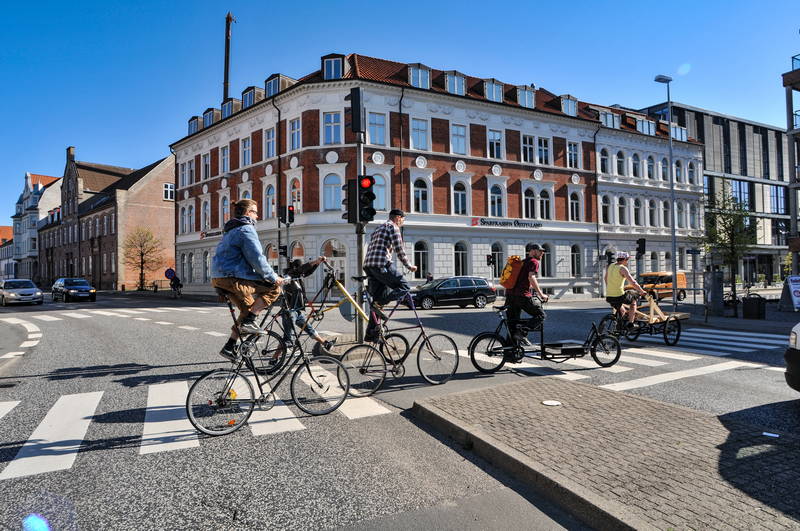 Group of cyclists in Denmark riding vintage bicycles through crosswalk. Stock Photography Free for Commercial Use.