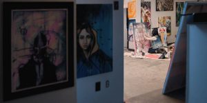 Artist in Vancouver studio working with oil paints kneeling on ground painting. Stock Photography Free for Commercial Use.