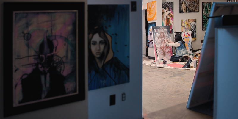 Artist in Vancouver studio working with oil paints kneeling on ground painting. Stock Photography Free for Commercial Use.