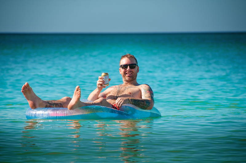 Man in inner-tube on all-inclusive vacation in clear Caribbean water. Stock Photography Free for Commercial Use.