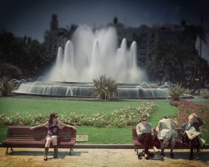 People on bench in front of lawn and waterfall. Stock Photography Free for Commercial Use.