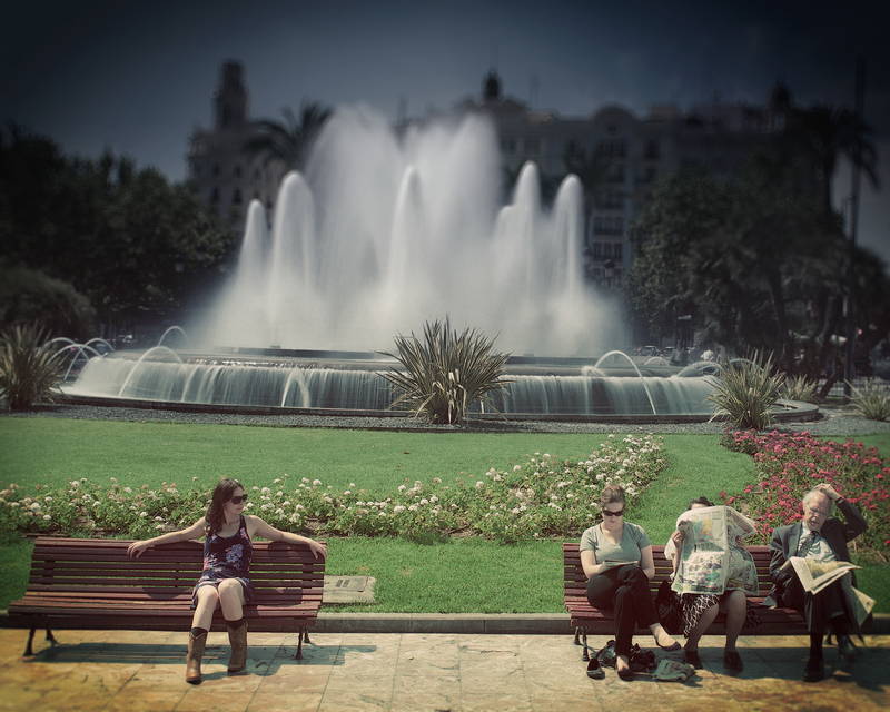 People on bench in front of lawn and waterfall. Stock Photography Free for Commercial Use.