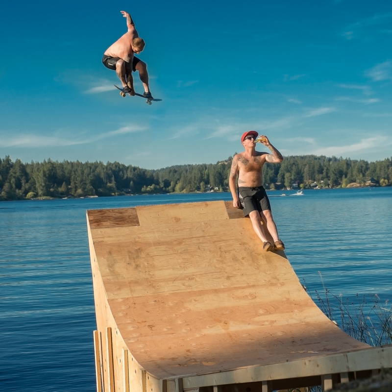Skateboard ramp with rider launching into lake. Stock Photography Free for Commercial Use.