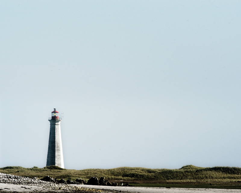 Lighthouse on a cliff on a clear day. Stock Photography Free for Commercial Use.